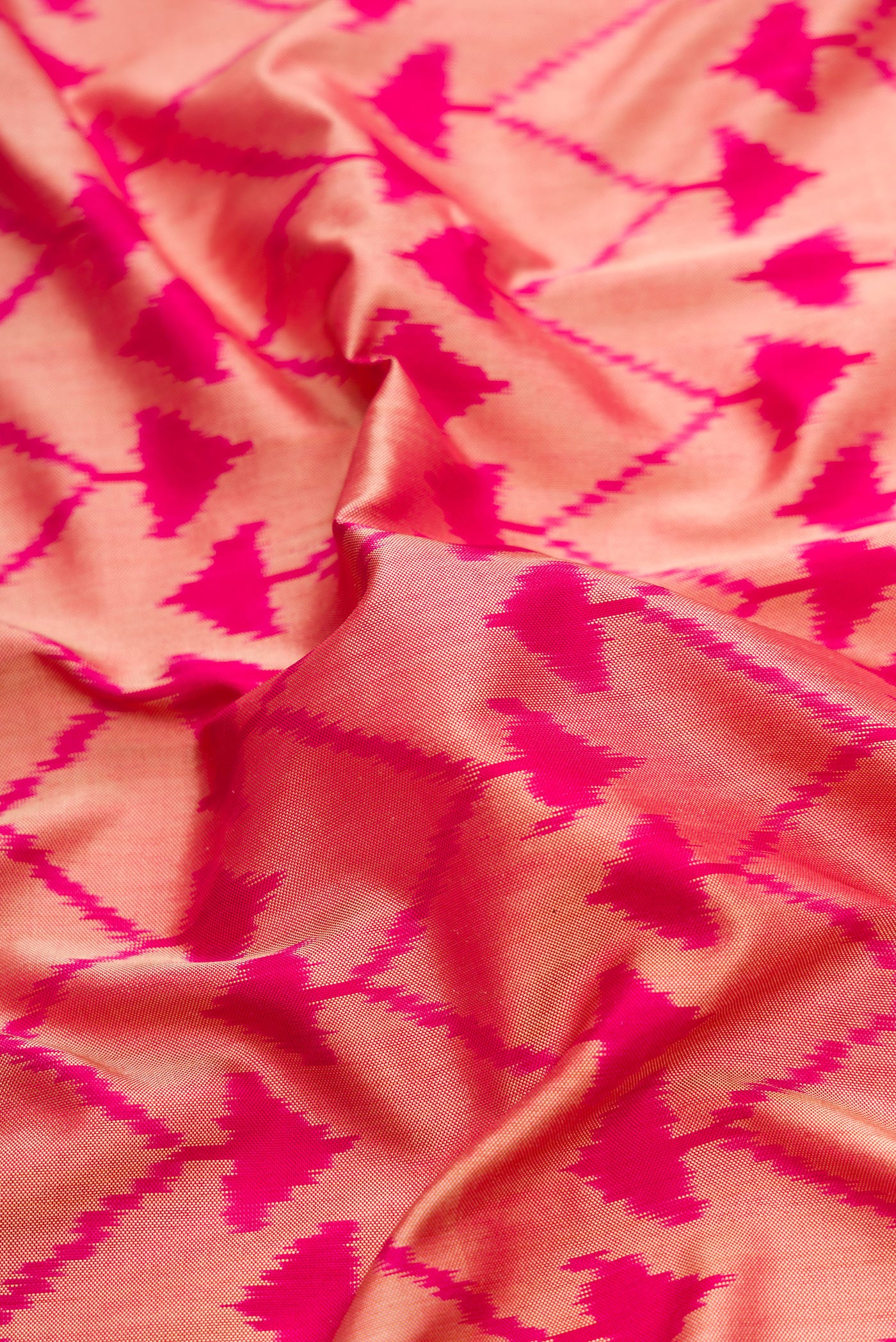 Close up of Pink Dual Tone Double Ikat Saree with Ikat Print on the body and Plain Border.  displaying folds