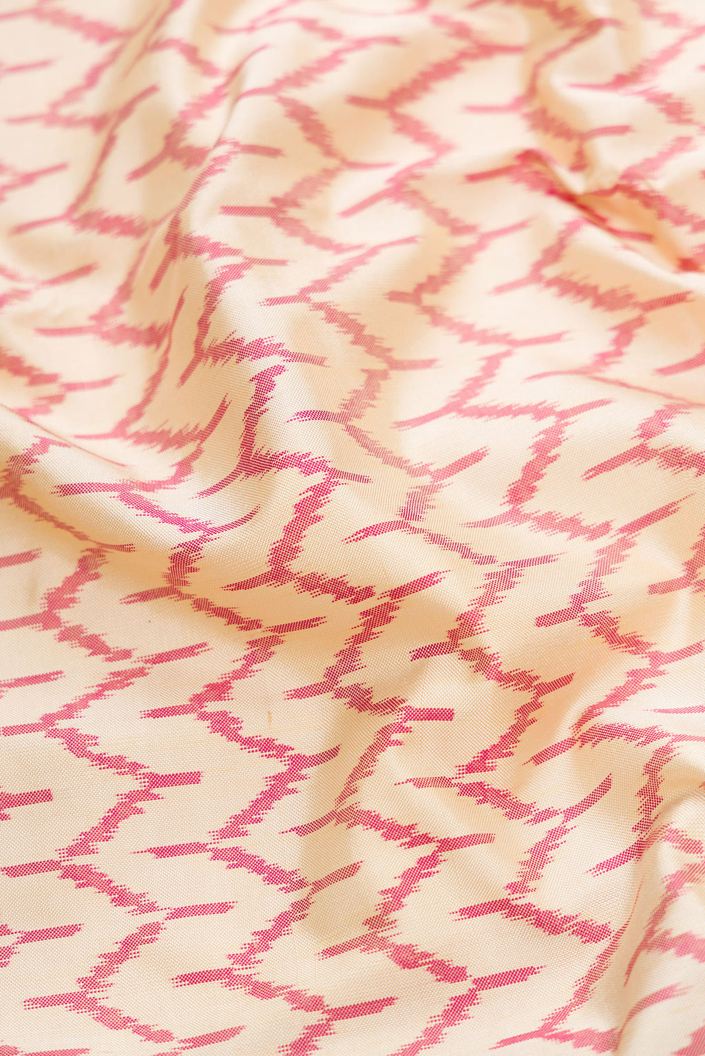 Close up of Off White Dual Tone Double Ikat Saree with Ikat Print on the body and Temple Border.  displaying folds