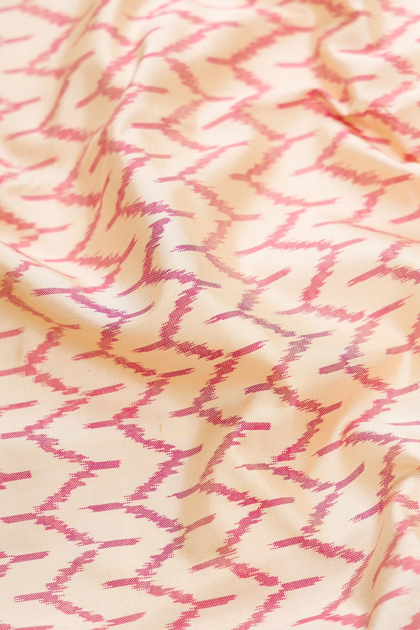 Close up of Off White Dual Tone Double Ikat Saree with Ikat Print on the body and Temple Border.  displaying folds