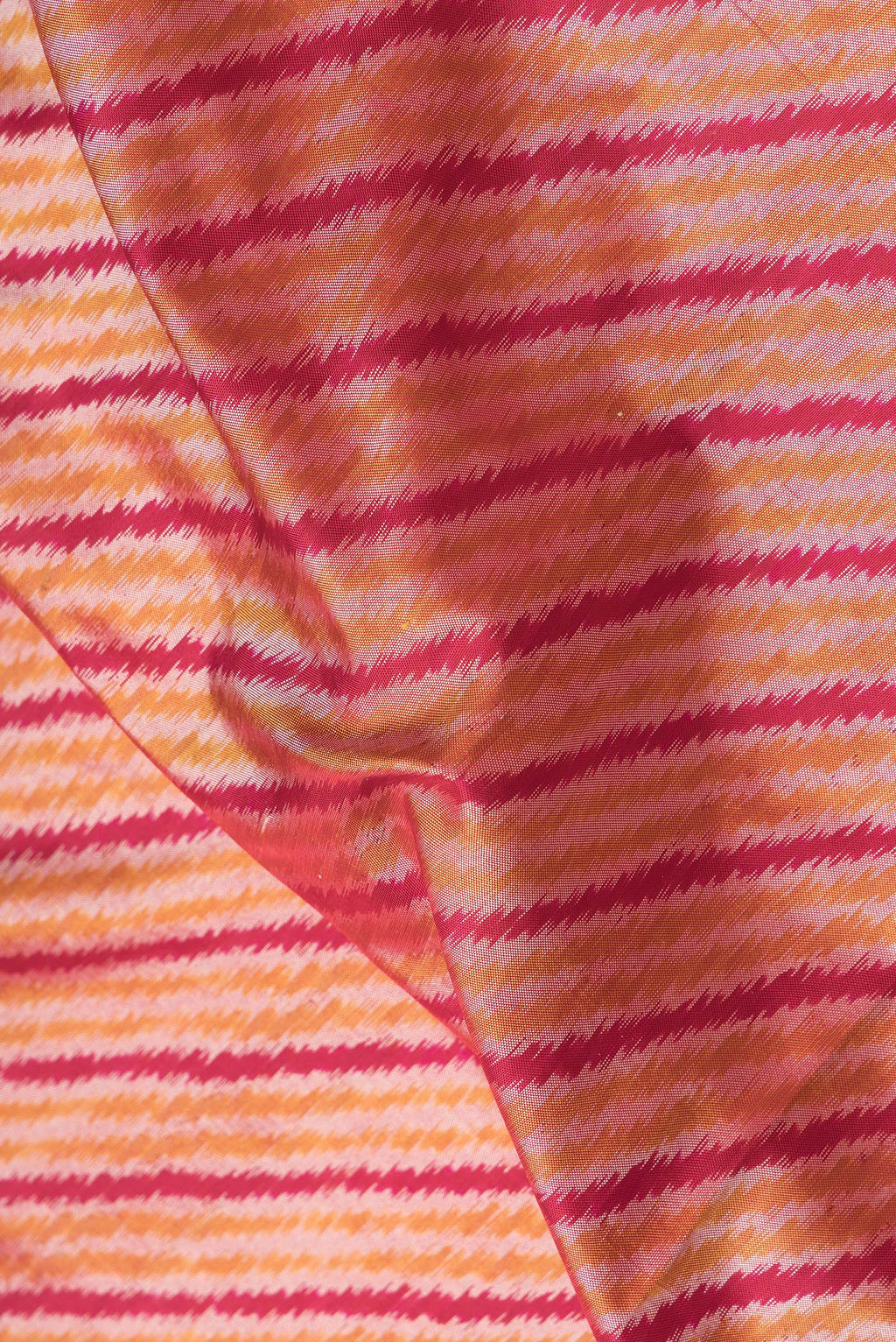 Close up of Maroon Dual Tone Double Ikat Saree with Ikat Print on the body and Plain Border.  displaying folds
