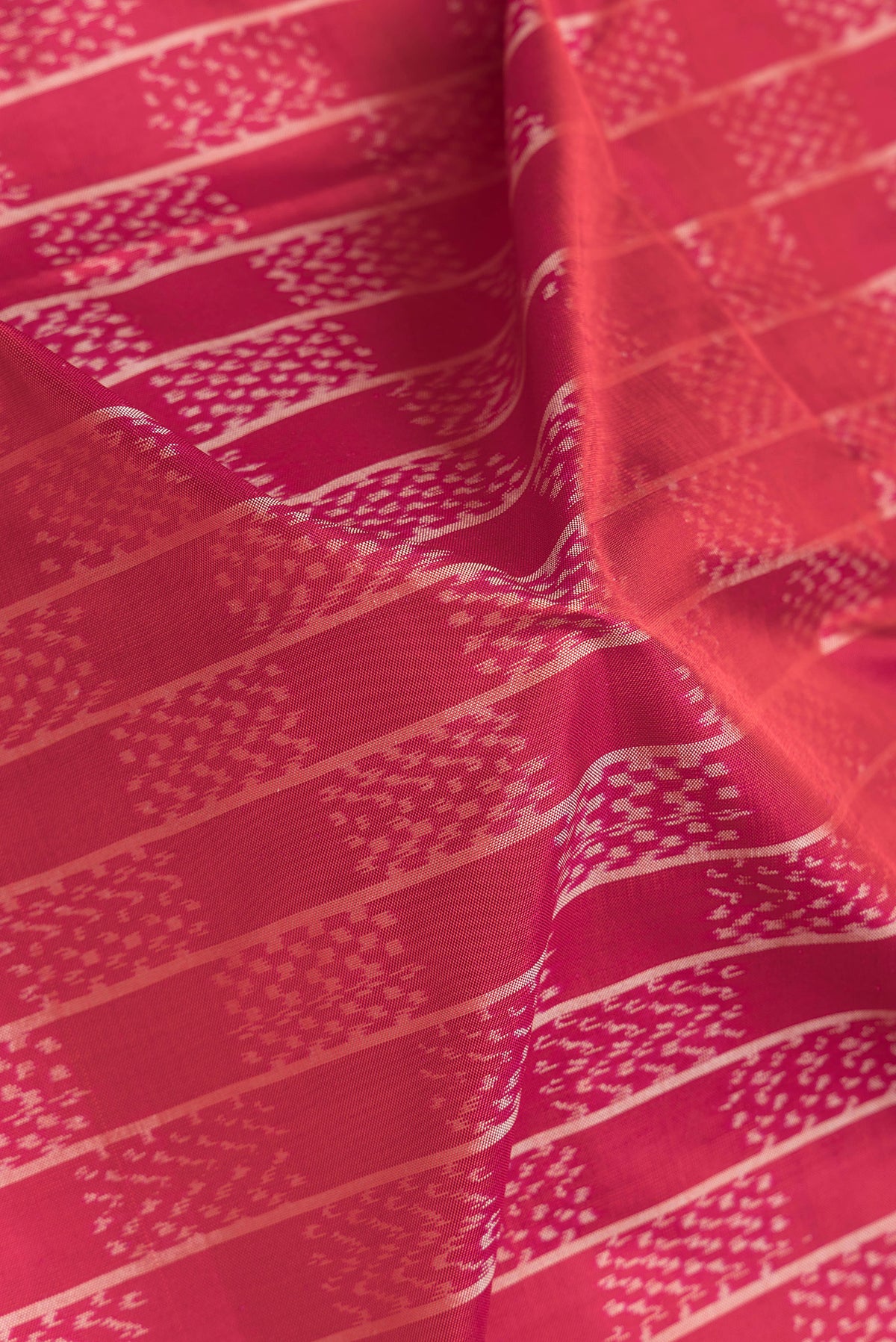 Close up of Pink Dual Tone Double Ikat Saree with Ikat Print on the body and Plain Border.  displaying folds