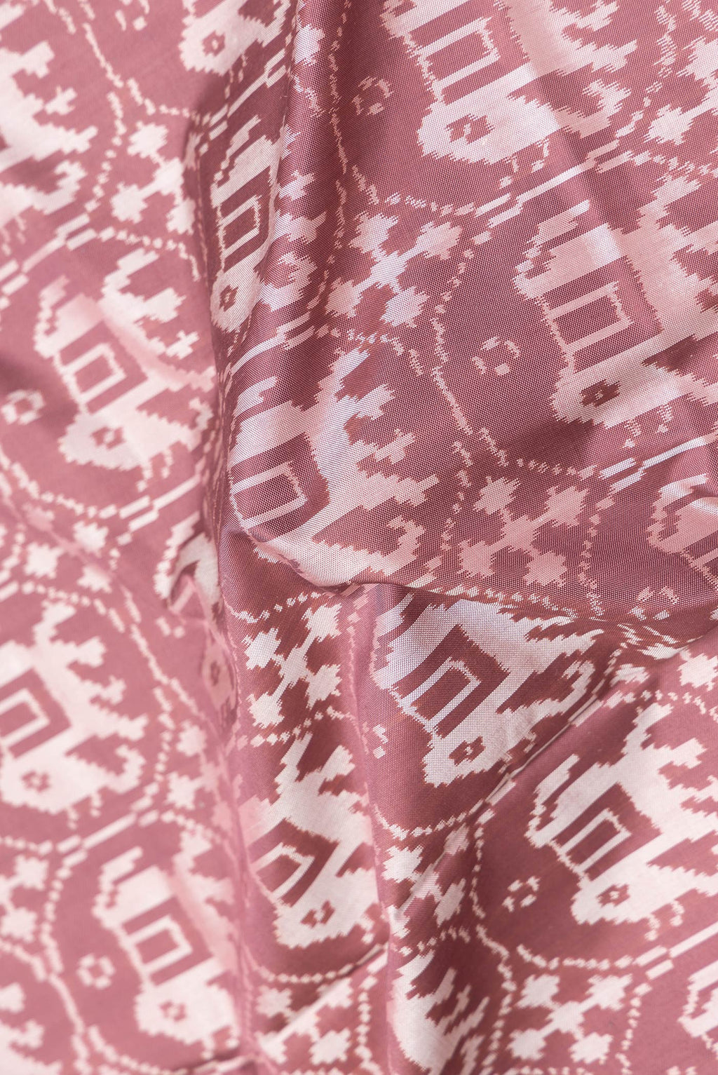 Close up of Brown Dual Tone Double Ikat Saree with Ikat Print on the body and Zari Border.  displaying folds