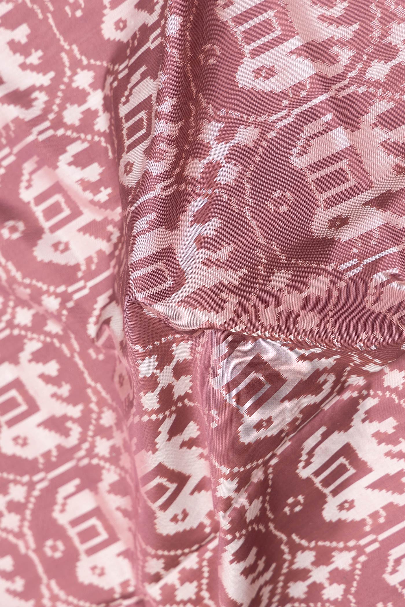 Close up of Brown Dual Tone Double Ikat Saree with Ikat Print on the body and Zari Border.  displaying folds
