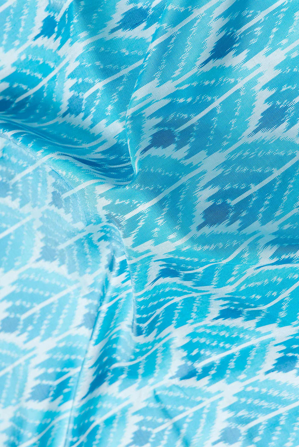 Close up of Sky Blue Dual Tone Double Ikat Saree with Ikat Print on the body and Plain Border.  displaying folds