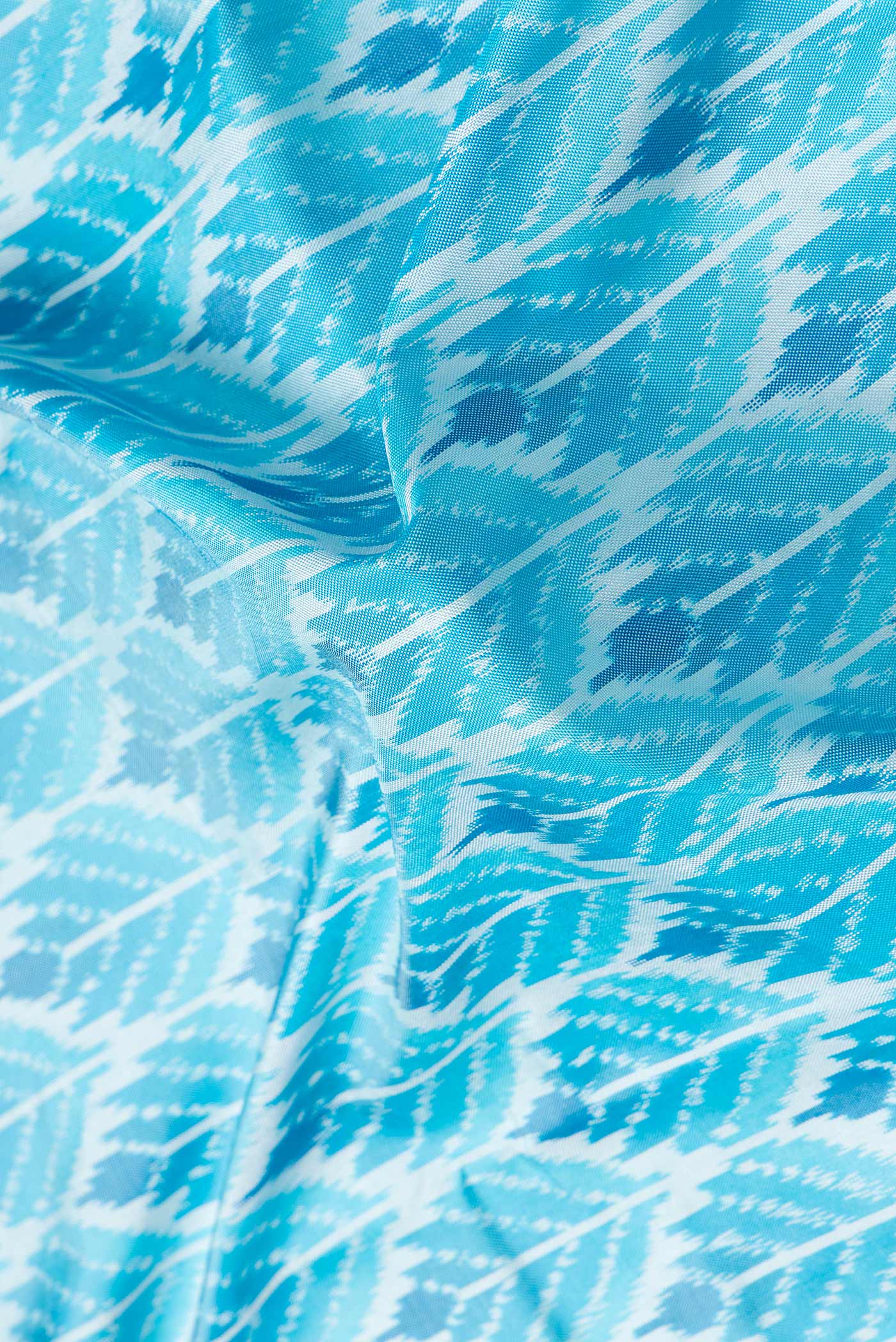 Close up of Sky Blue Dual Tone Double Ikat Saree with Ikat Print on the body and Plain Border.  displaying folds