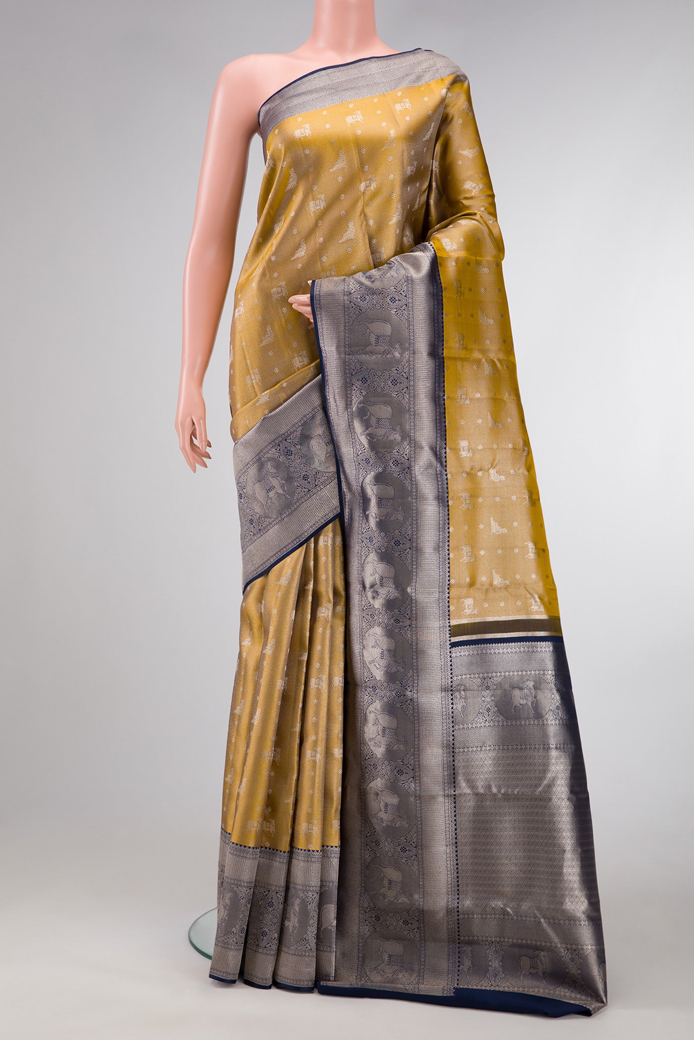 Gold Dual Tone Kanjivaram Tissue Silk Saree with Zari Brocade on the body and Fancy Border.  displayed on a mannequin