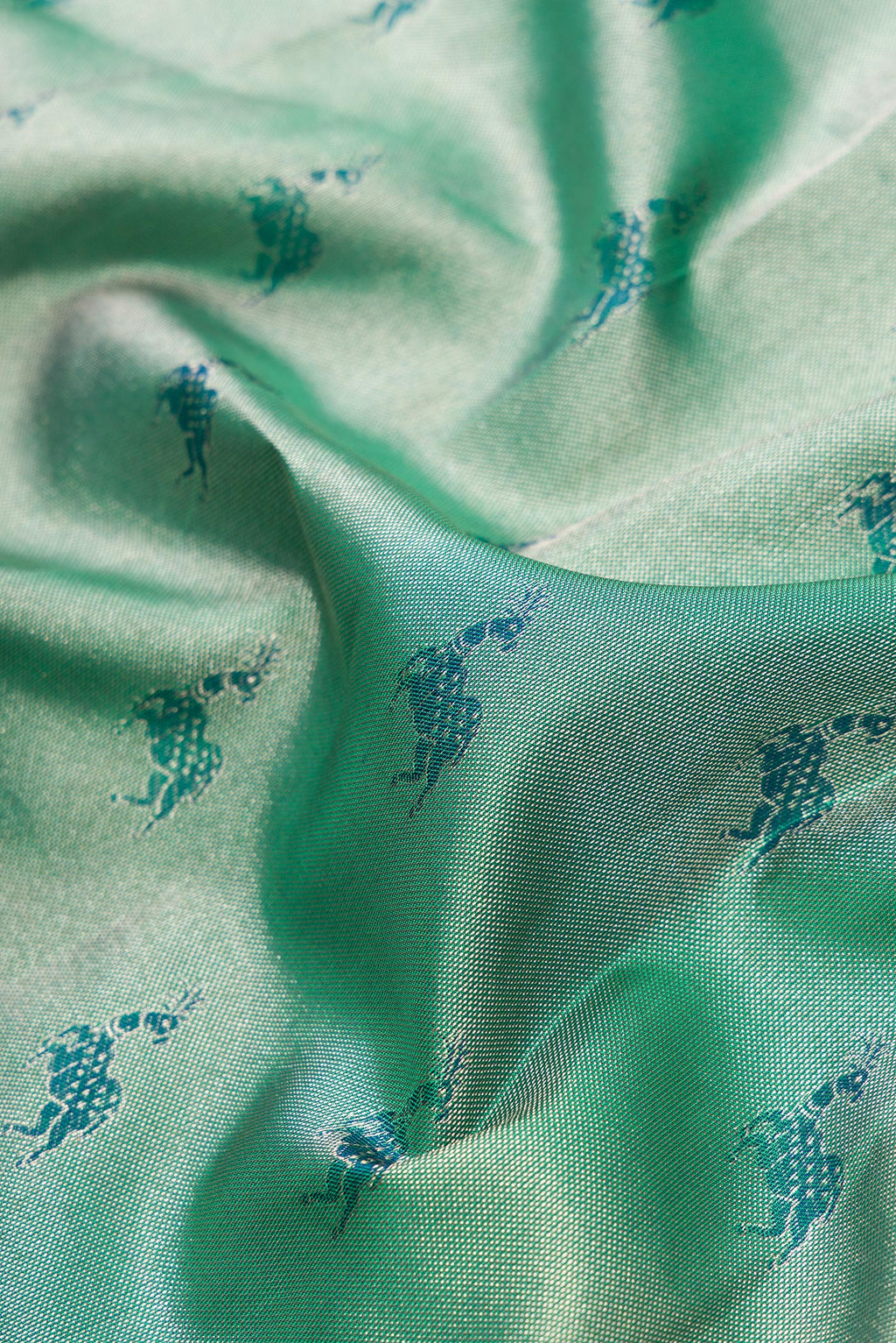 Close up of Green Dual Tone Kanjivaram Tissue Silk Saree with Zari Brocade on the body and Fancy Border.  displaying folds