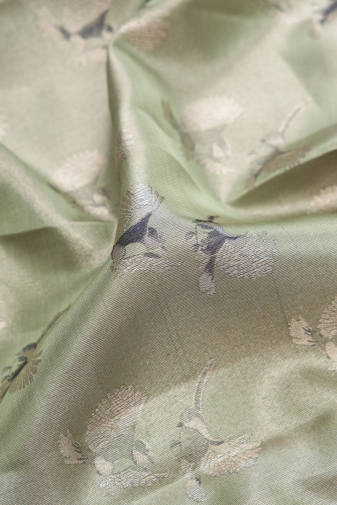 Close up of Sea Green Dual Tone Kanjivaram Tissue Silk Saree with Zari Brocade on the body and Fancy Border.  displaying folds