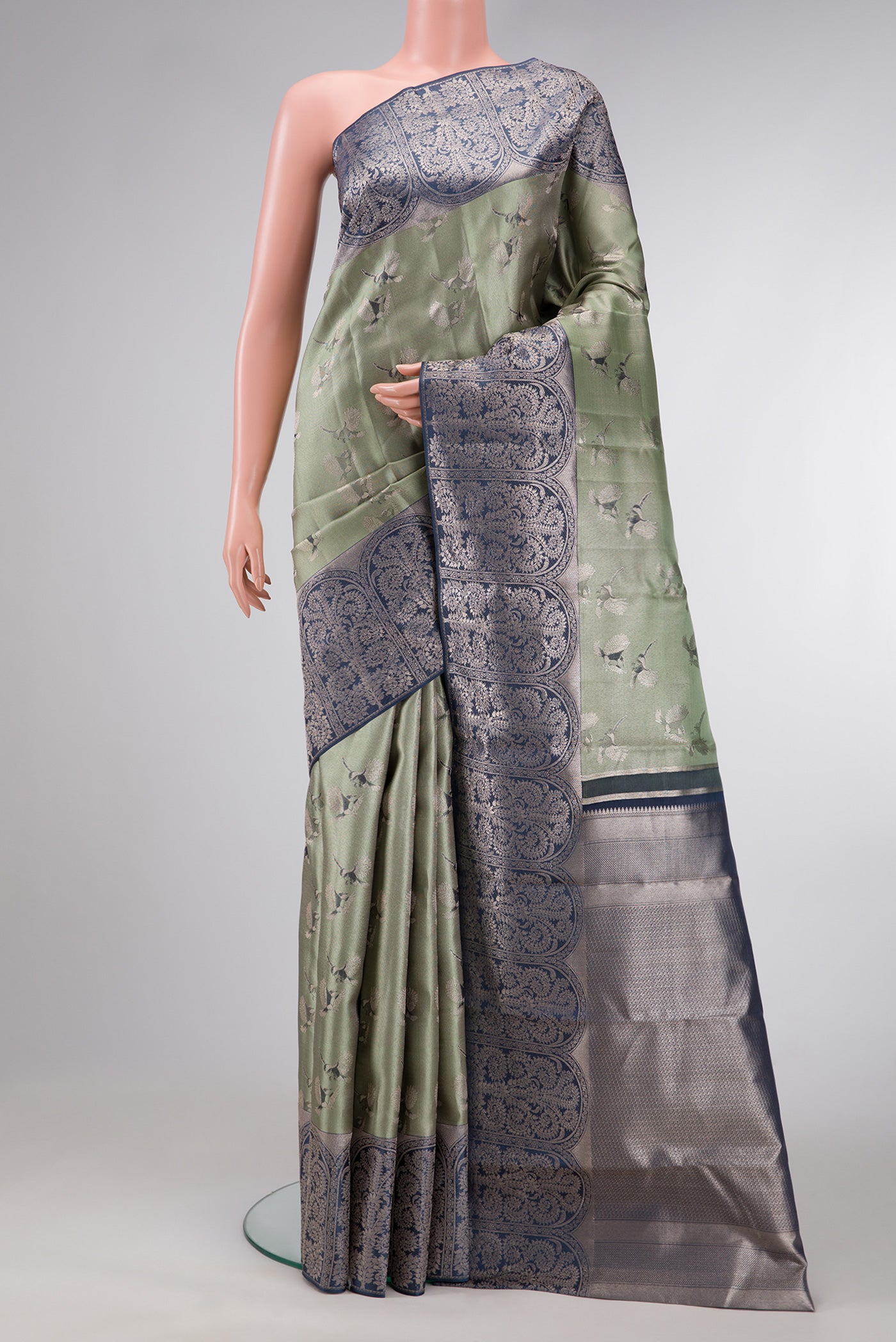 Sea Green Dual Tone Kanjivaram Tissue Silk Saree with Zari Brocade on the body and Fancy Border.  displayed on a mannequin