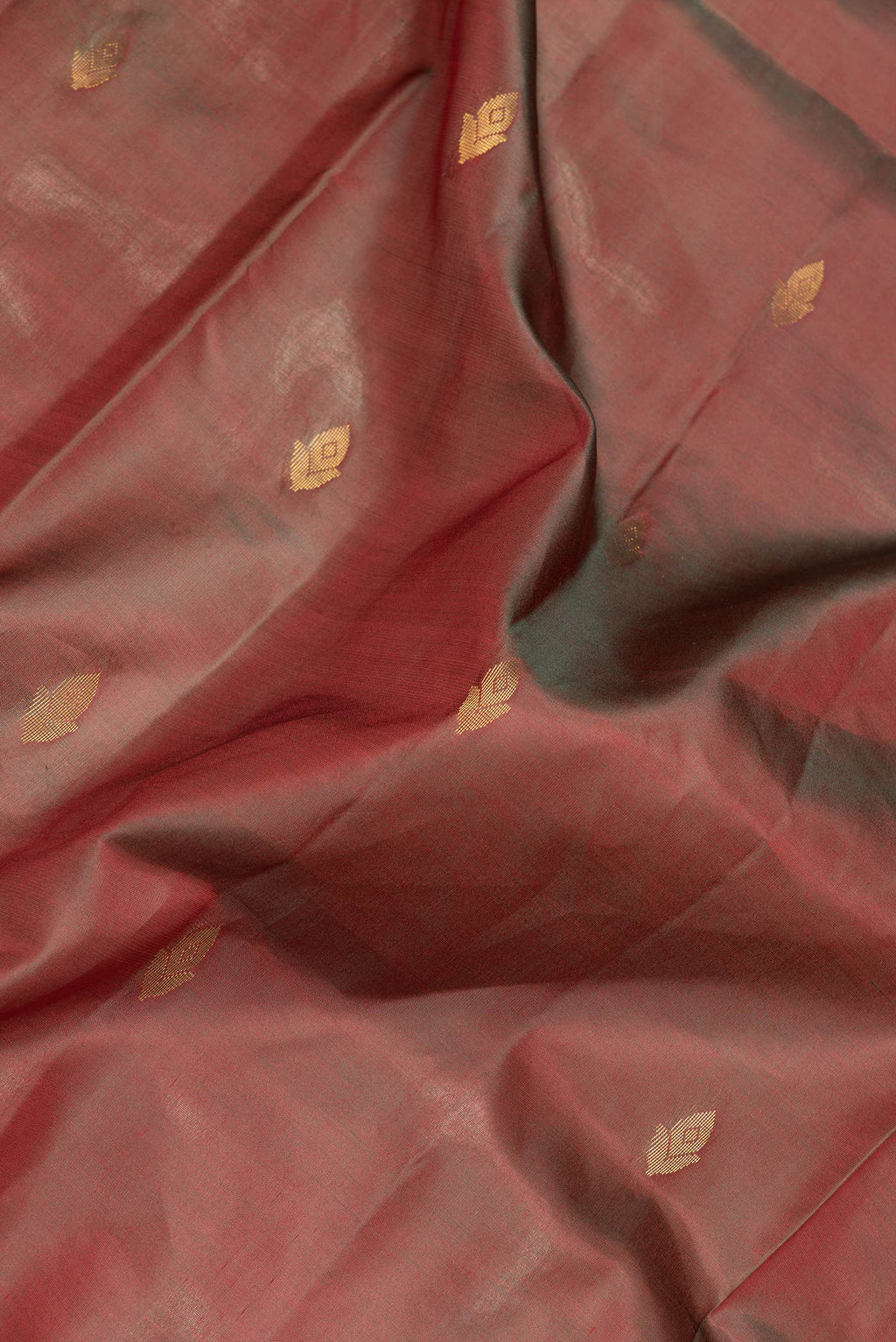 Close up of Maroon Dual Tone Soft Silk Saree with Zari Butta on the body and Fancy Border.  displaying folds