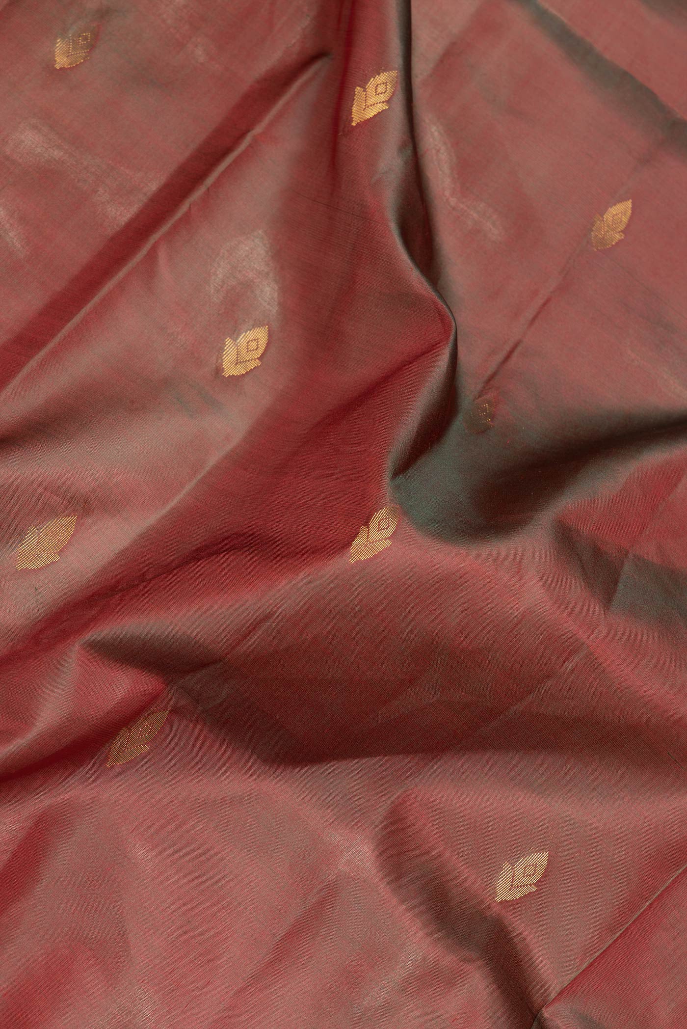 Close up of Maroon Dual Tone Soft Silk Saree with Zari Butta on the body and Fancy Border.  displaying folds