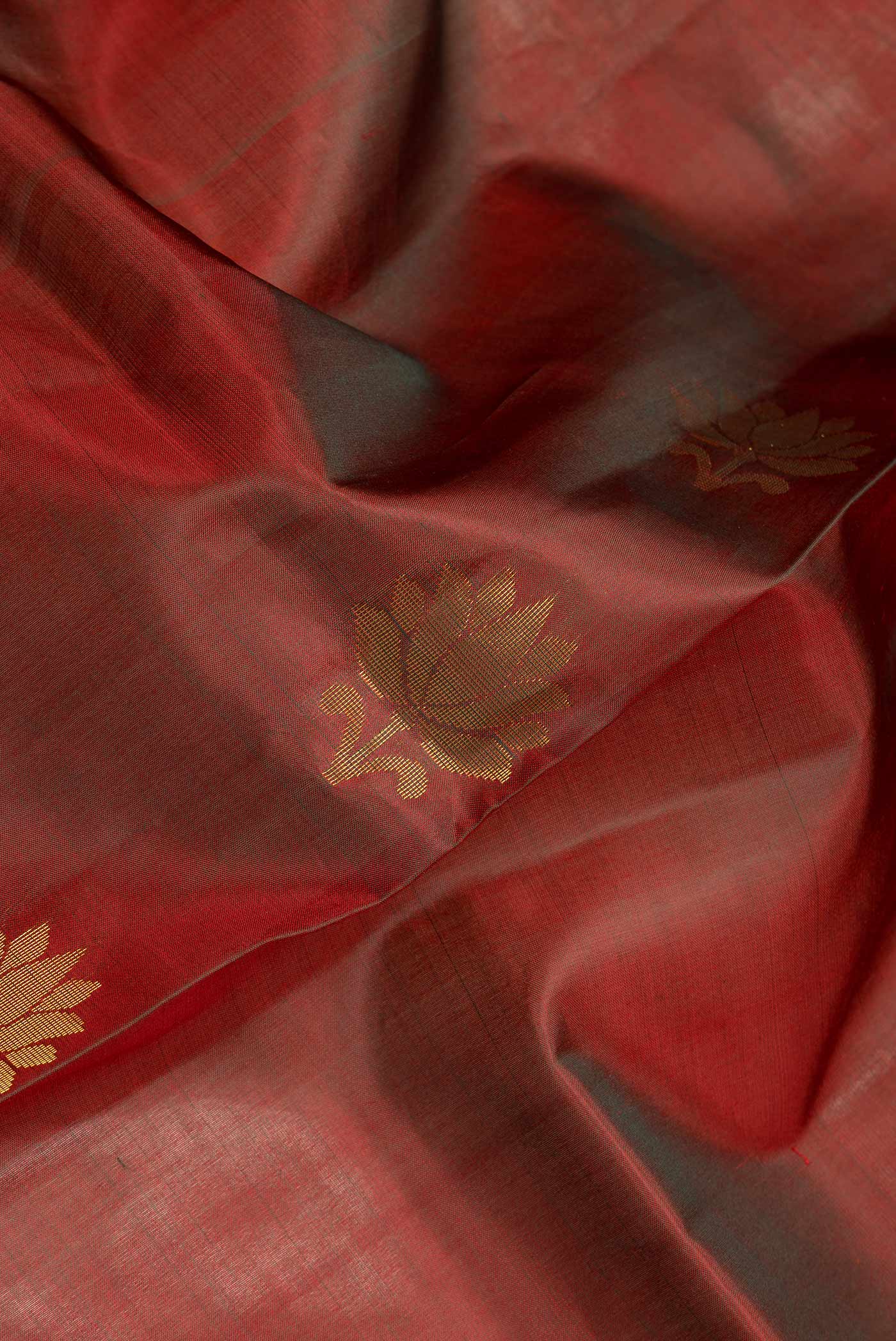 Close up of Maroon Dual Tone Soft Silk Saree with Zari Butta on the body and Zari Border.  displaying folds