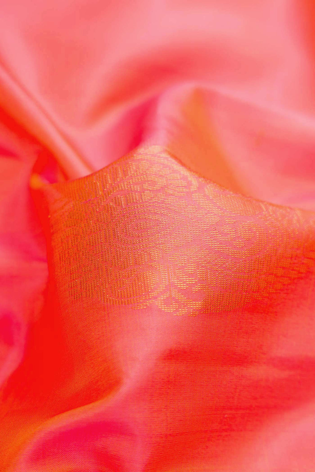 Close up of Brick Orange Dual Tone Soft Silk Saree with Zari Butta on the body and Zari Border.  displaying folds