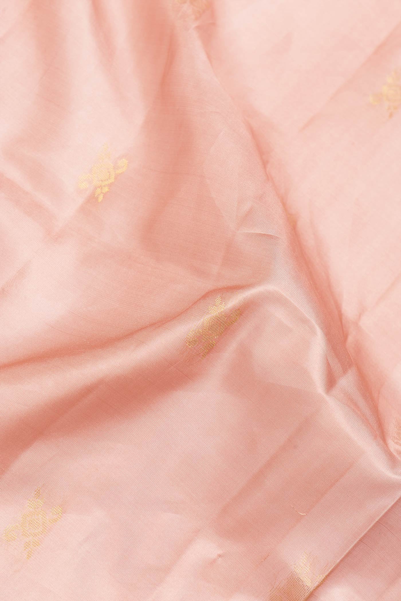 Close up of Peach Dual Tone Soft Silk Saree with Zari Butta on the body and Fancy Border.  displaying folds