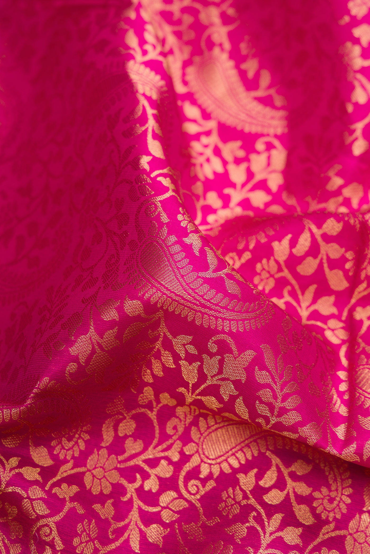 Close up of Dark Pink Kanchipuram Silk Saree with Zari Brocade on the body and Zari Border.  displaying folds