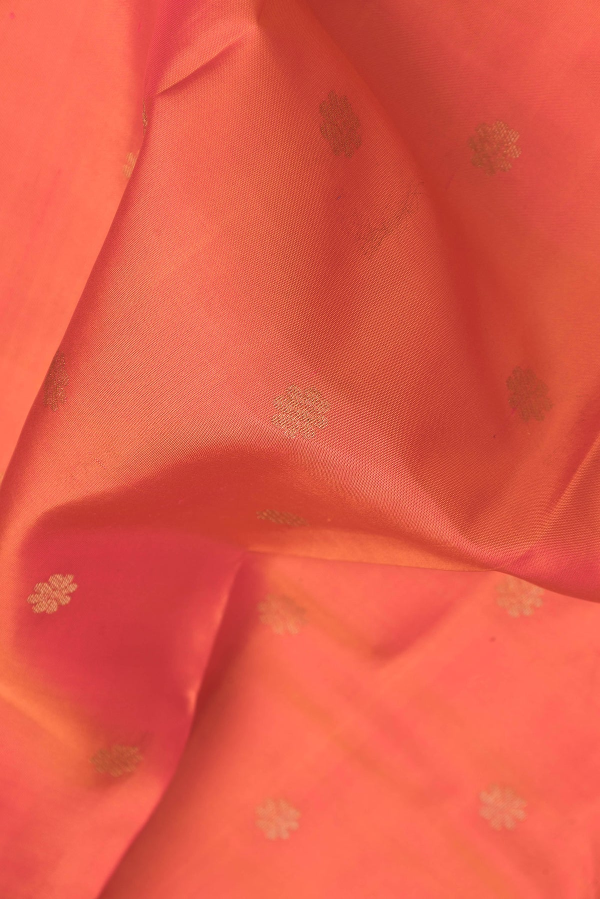Close up of Orange Dual Tone Kanjivaram Silk Saree with Zari Butta on the body and Zari Border.  displaying folds