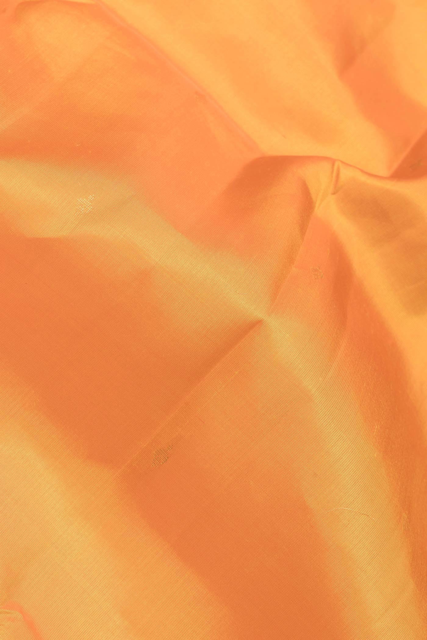 Close up of Orange Dual Tone Kanjivaram Silk Saree with Zari Butta on the body and Zari Border.  displaying folds