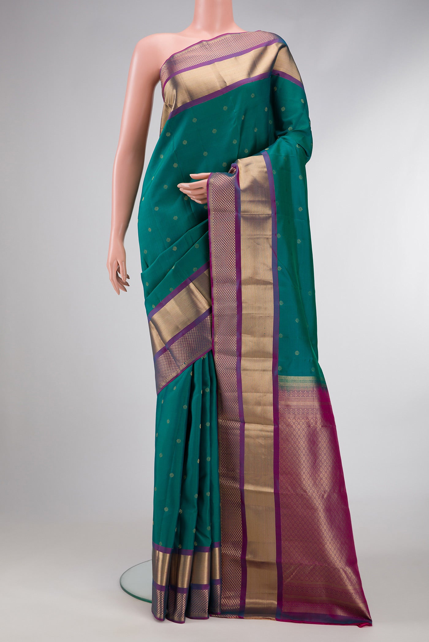 Green Dual Tone Kanchipuram Silk Saree with Zari Butta on the body and Zari Border.  displayed on a mannequin