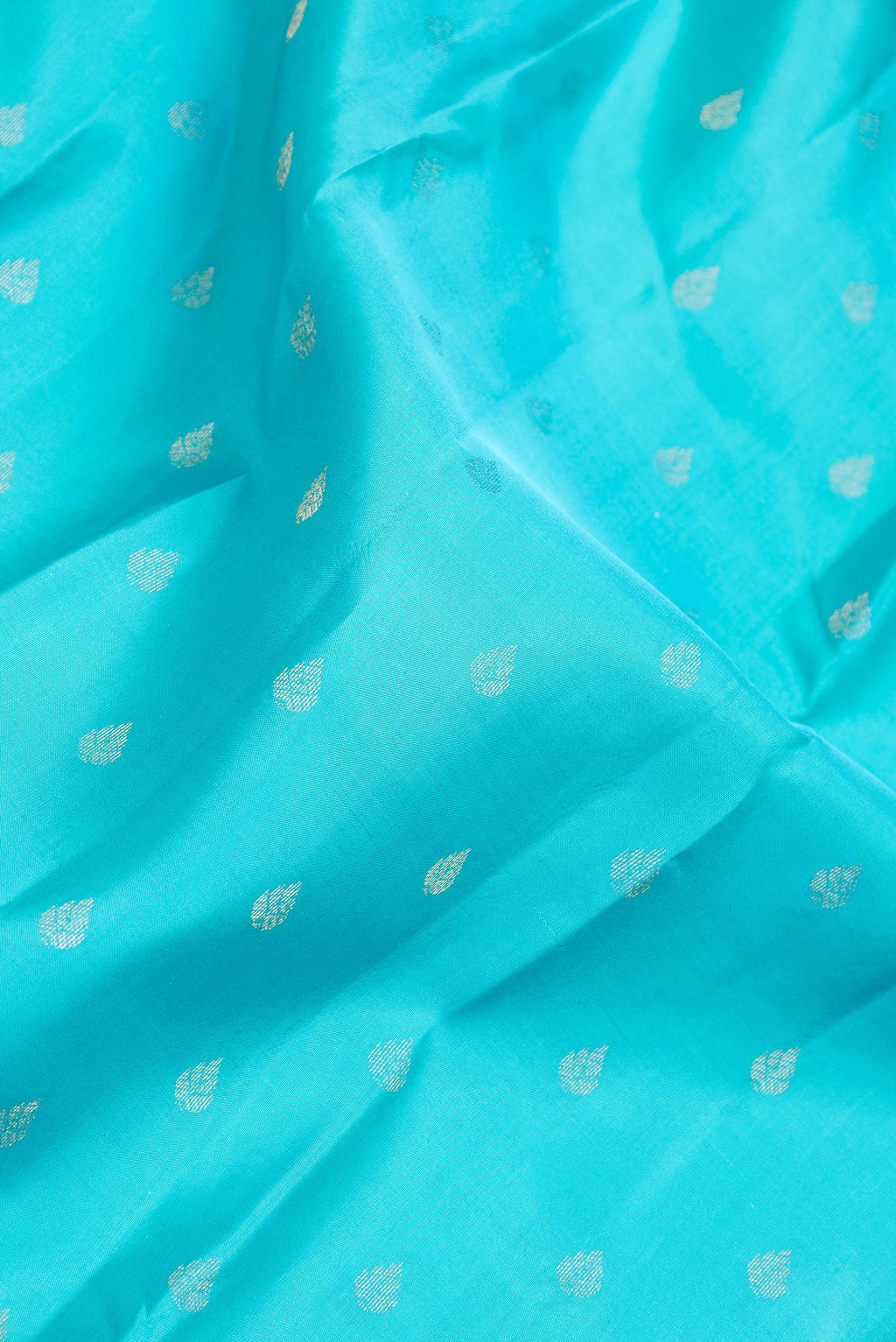 Close up of Sky Blue Dual Tone Kanchipuram Silk Saree with Zari Butta on the body and Zari And Thread Border.  displaying folds
