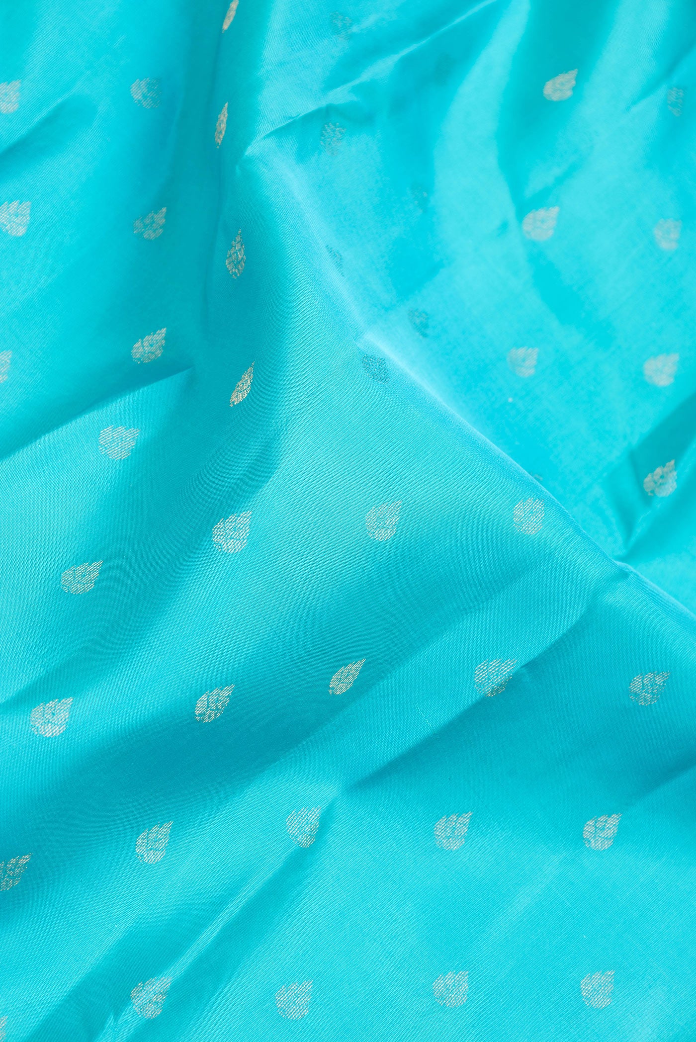 Close up of Sky Blue Dual Tone Kanchipuram Silk Saree with Zari Butta on the body and Zari And Thread Border.  displaying folds