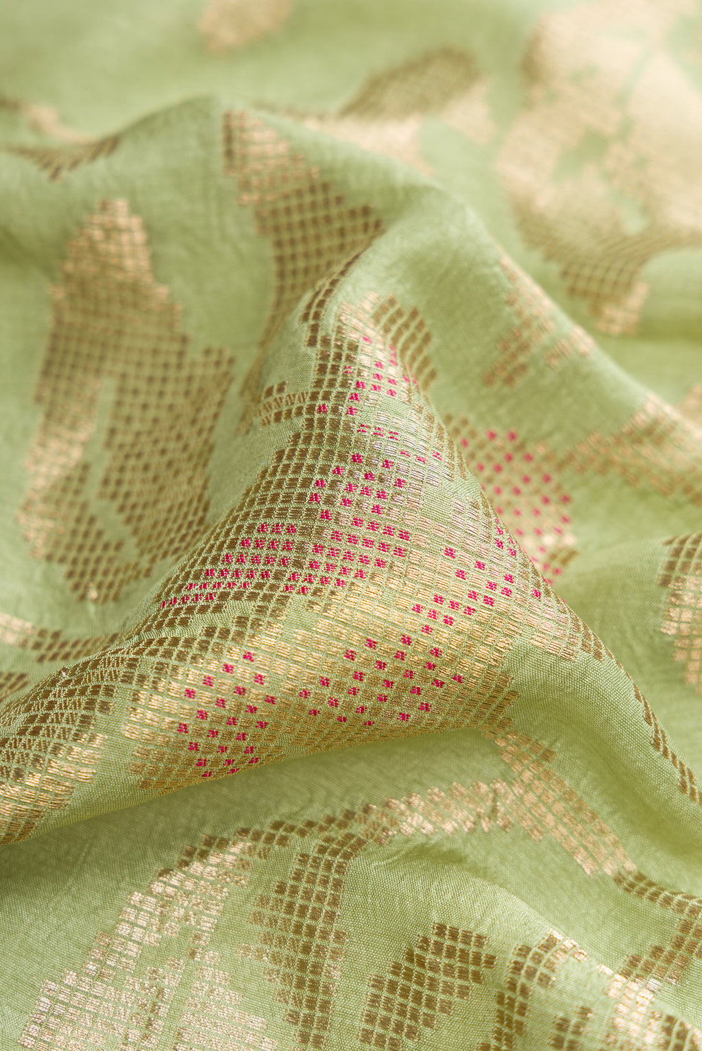 Close up of Pista Green Blended Bandhani Silk Saree with Zari Brocade on the body and Fancy Border.  displaying folds