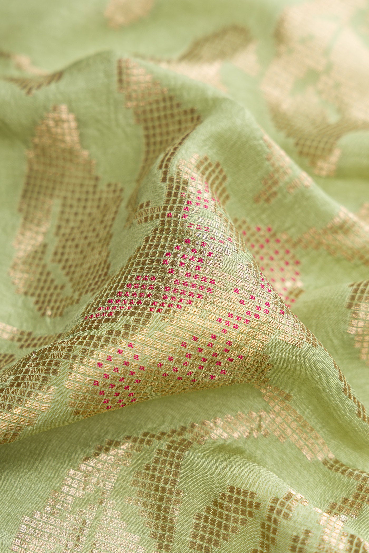 Close up of Pista Green Blended Bandhani Silk Saree with Zari Brocade on the body and Fancy Border.  displaying folds