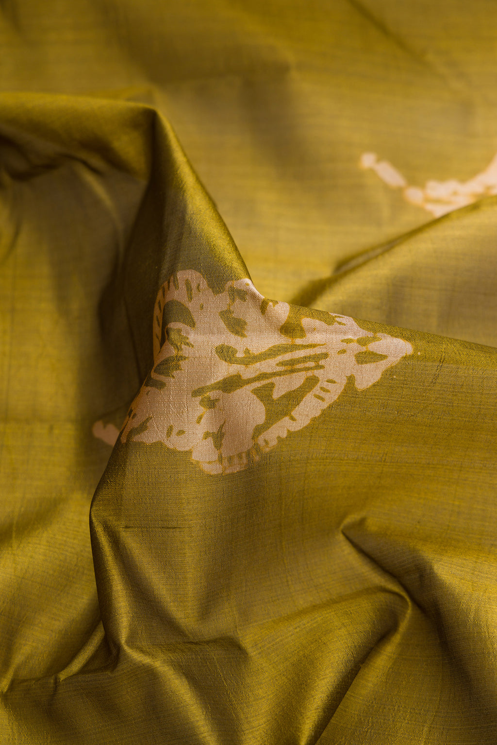 Close up of Mehandi Green Dual Tone Tussar Silk Saree with Printed design on the body and Printed Border.  displaying folds