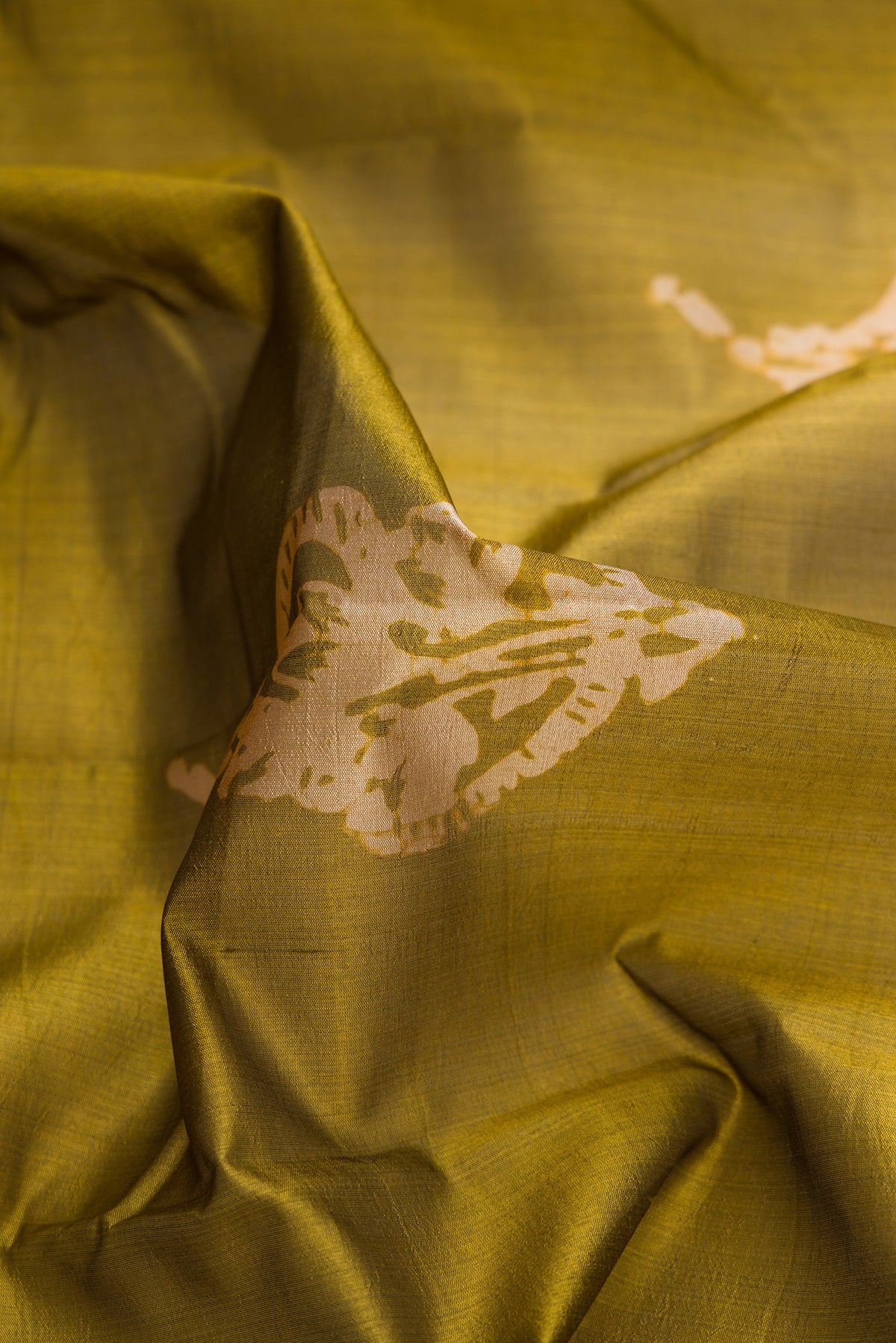 Close up of Mehandi Green Dual Tone Tussar Silk Saree with Printed design on the body and Printed Border.  displaying folds