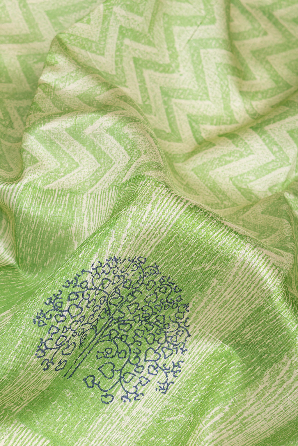 Close up of Green Tussar Silk Saree with Printed design on the body and Printed Border.  displaying folds