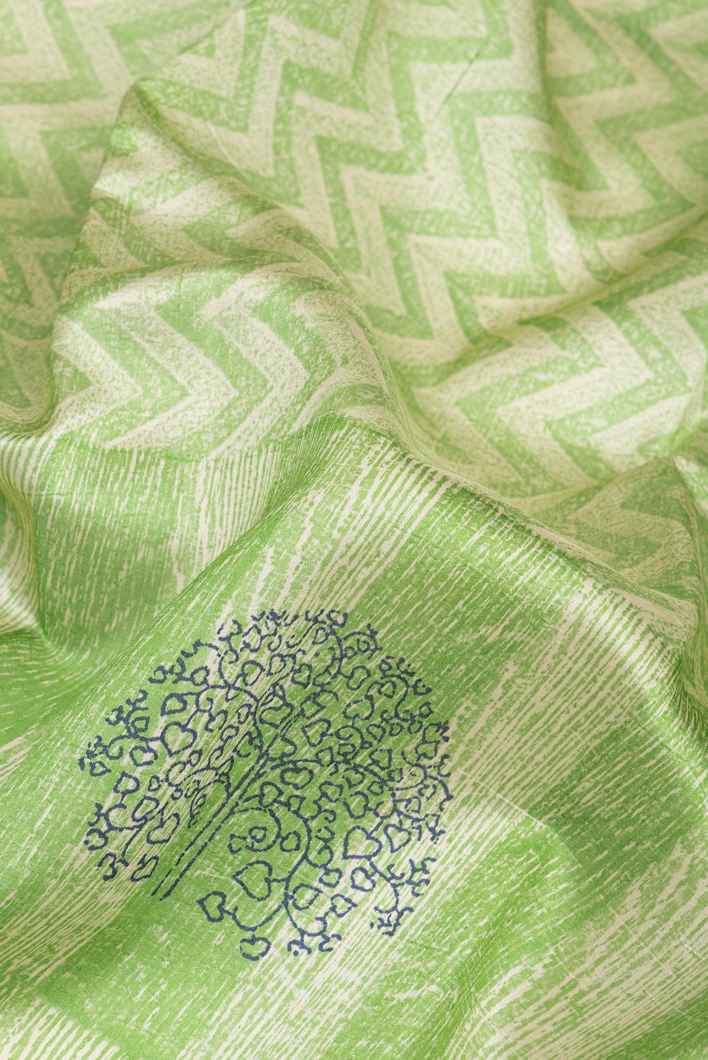Close up of Green Tussar Silk Saree with Printed design on the body and Printed Border.  displaying folds
