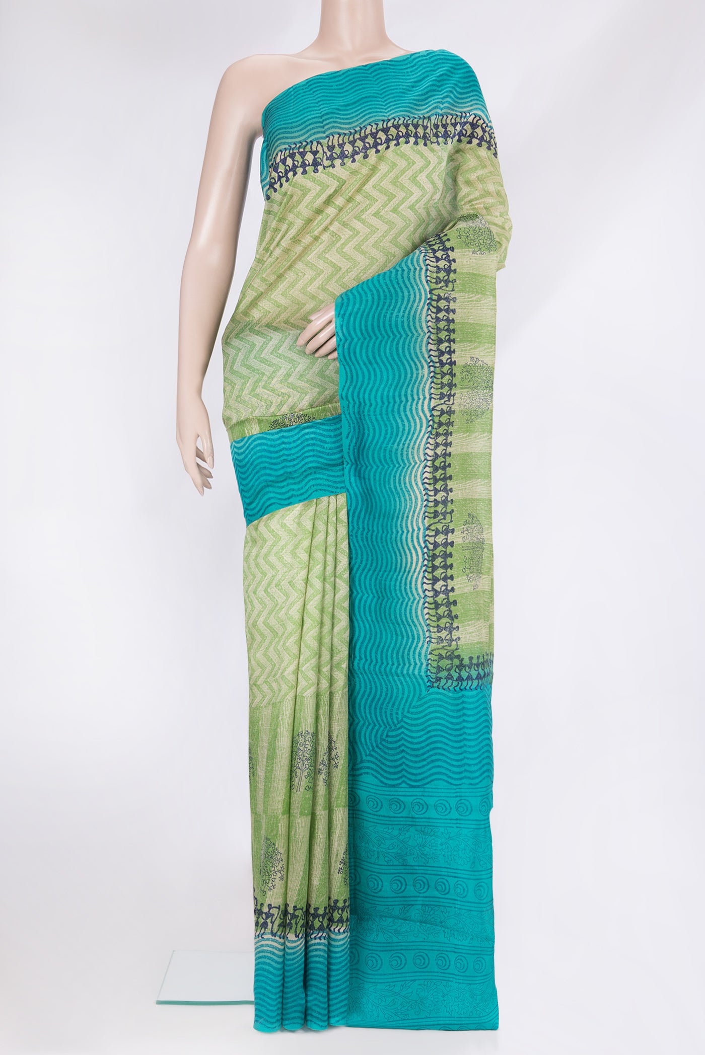 Green Tussar Silk Saree with Printed design on the body and Printed Border.  displayed on a mannequin