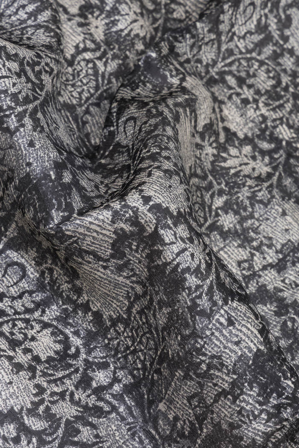 Close up of Black Tussar Silk Saree with Printed design on the body and Printed Border.  displaying folds
