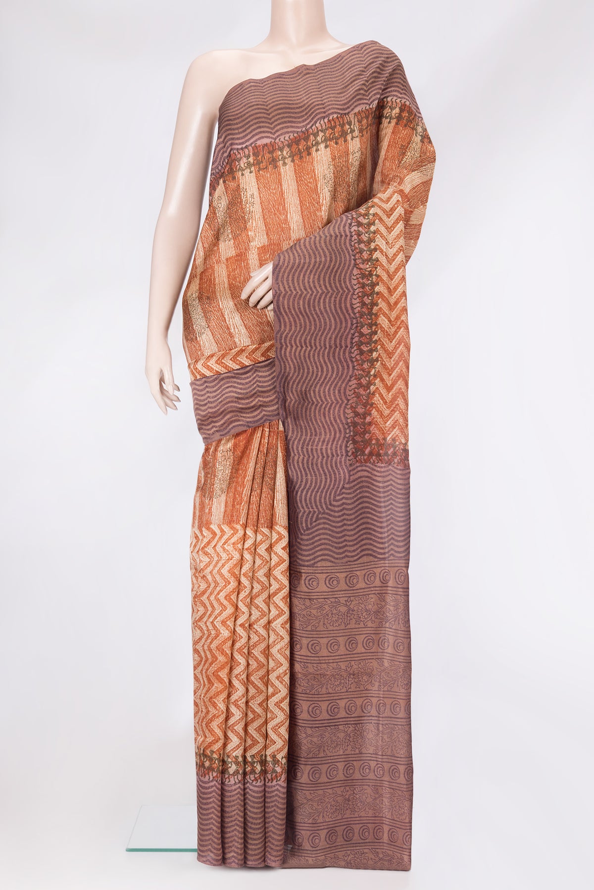 Brick Orange Tussar Silk Saree with Printed design on the body and Printed Border.  displayed on a mannequin