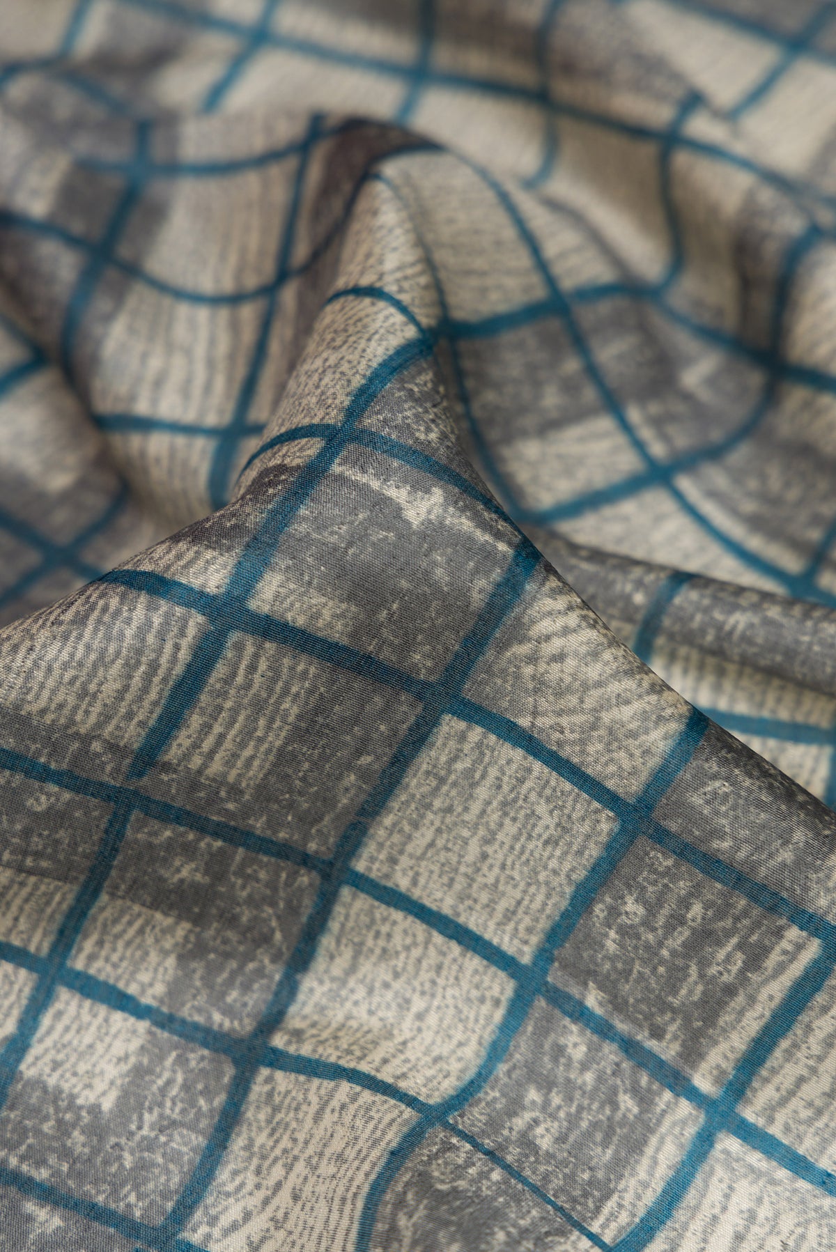 Close up of Grey Dual Tone Tussar Silk Saree with Checked design on the body and Fancy Border.  displaying folds