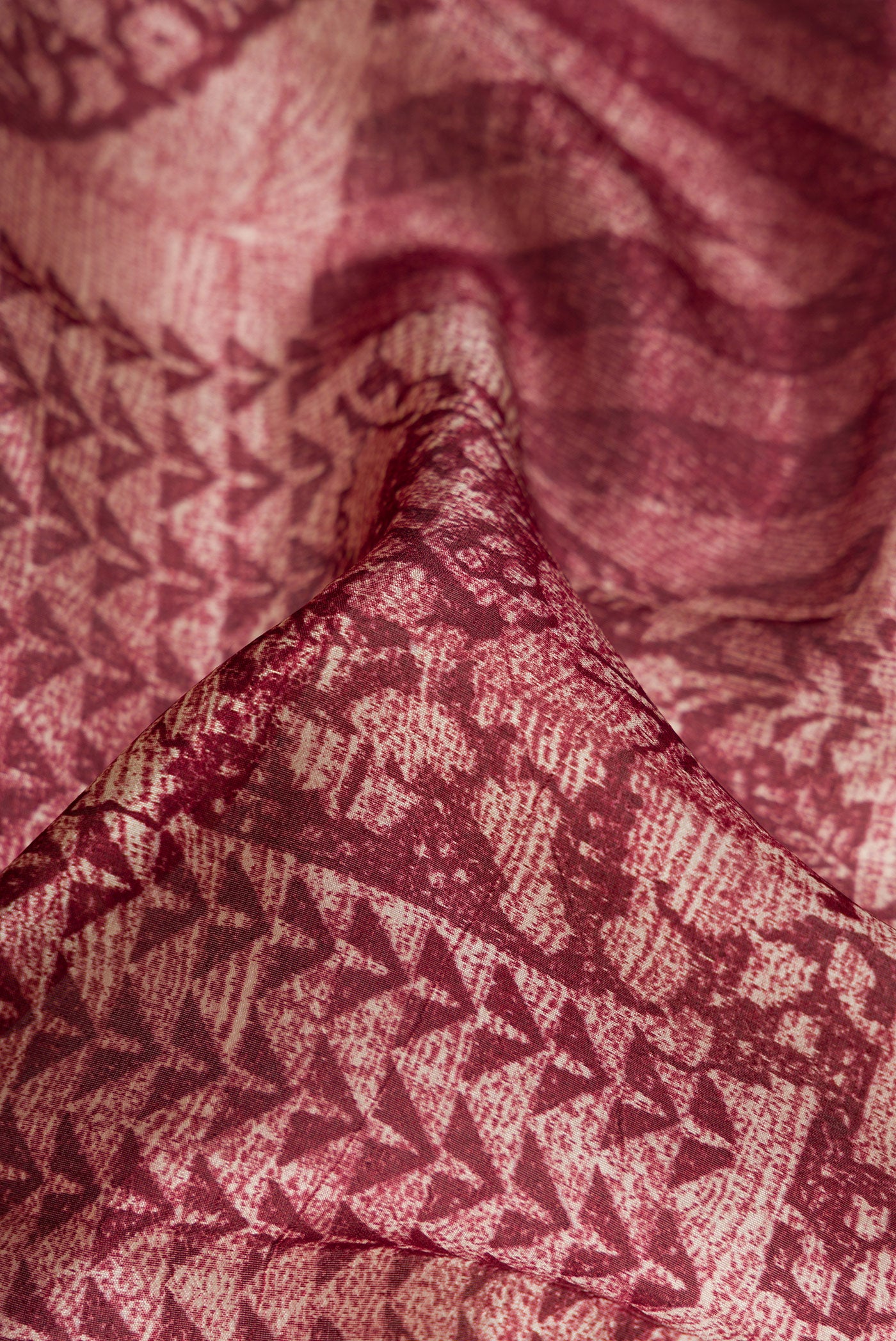 Close up of Maroon Dual Tone Tussar Silk Saree with Printed design on the body and Printed Border.  displaying folds
