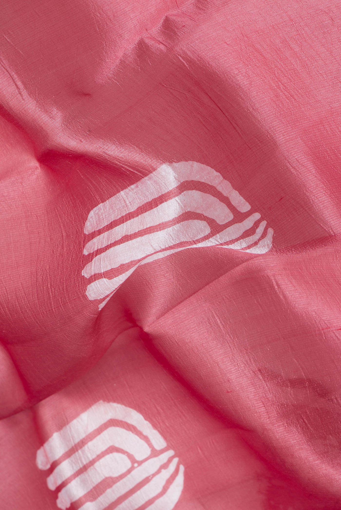Close up of Pink Tussar Silk Saree with Printed design on the body and Printed Border.  displaying folds