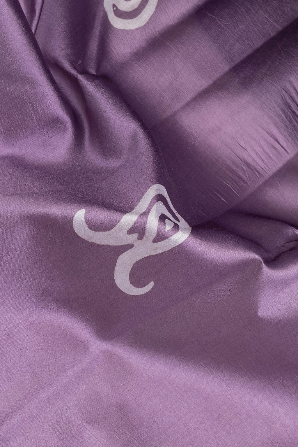 Close up of Lavender Dual Tone Tussar Silk Saree with Batik Print on the body and Printed Border.  displaying folds