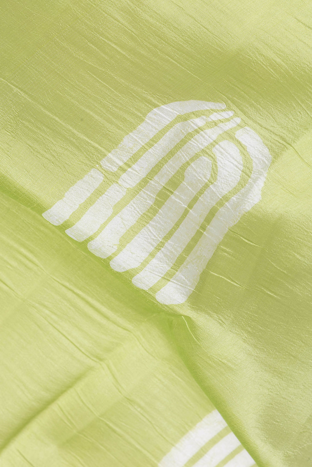 Close up of Pista Green Tussar Silk Saree with Printed design on the body and Printed Border.  displaying folds