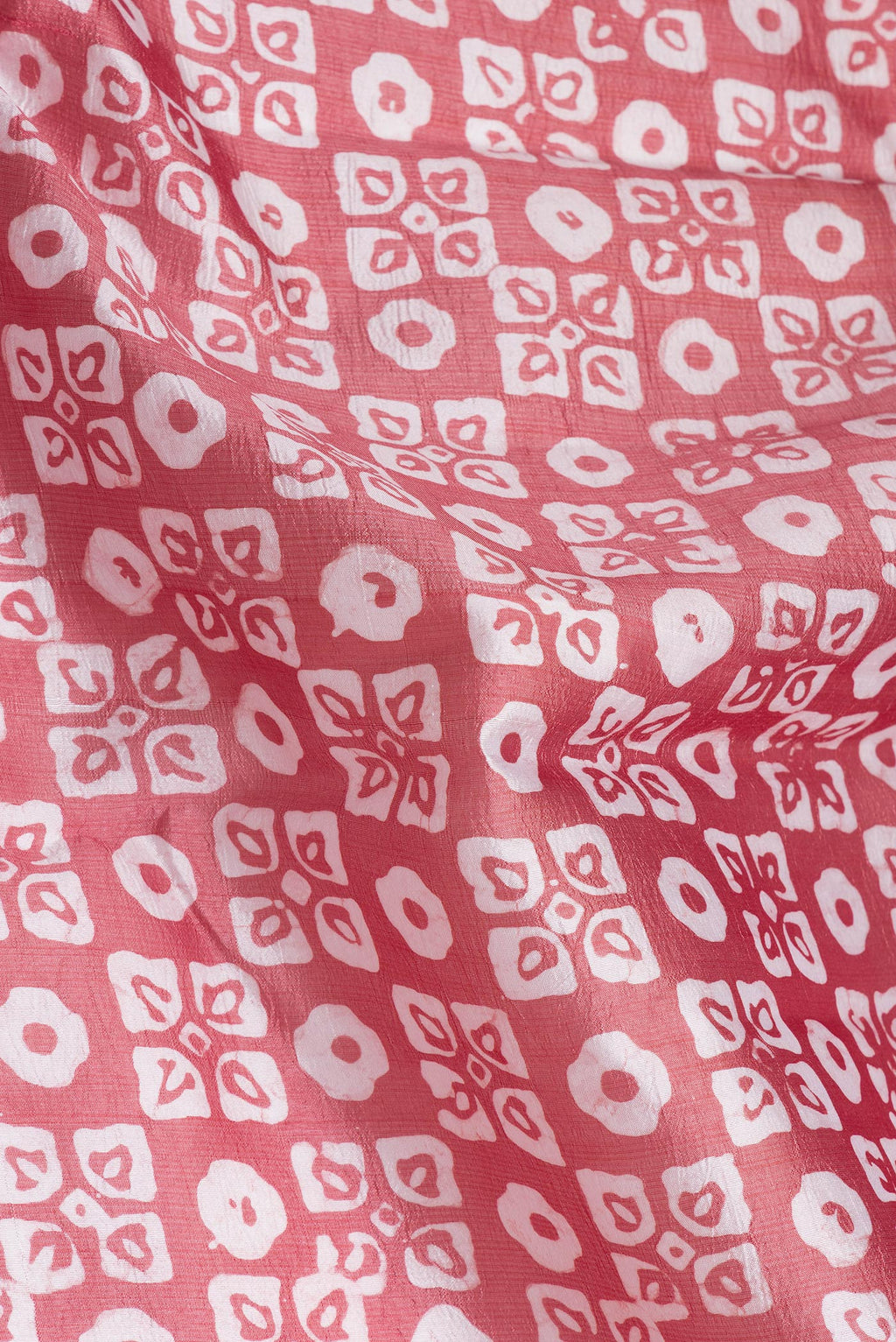 Close up of Peach Dual Tone Tussar Silk Saree with Batik Print on the body and Printed Border.  displaying folds