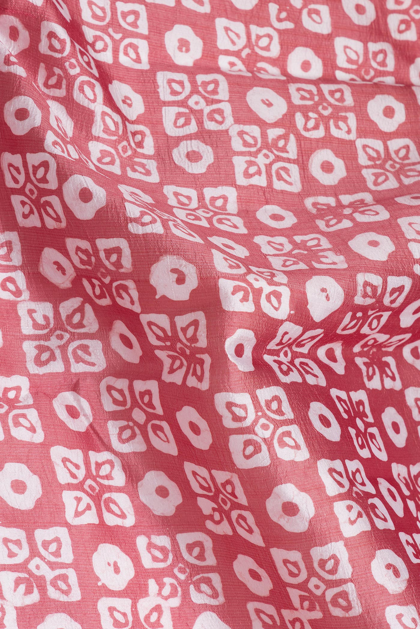 Close up of Peach Dual Tone Tussar Silk Saree with Batik Print on the body and Printed Border.  displaying folds