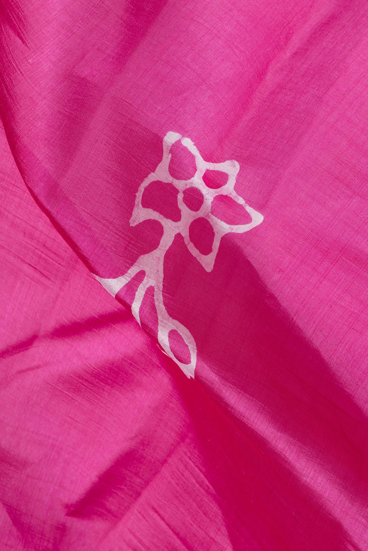 Close up of Rose pink Dual Tone Tussar Silk Saree with Batik Print on the body and Printed Border.  displaying folds