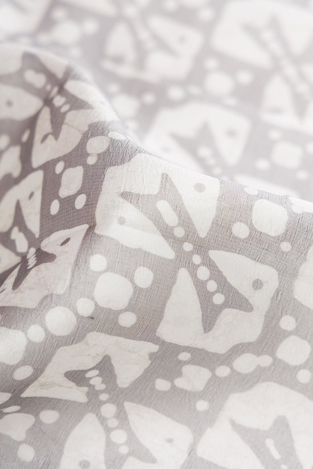 Close up of Grey Dual Tone Tussar Silk Saree with Printed design on the body and Printed Border.  displaying folds