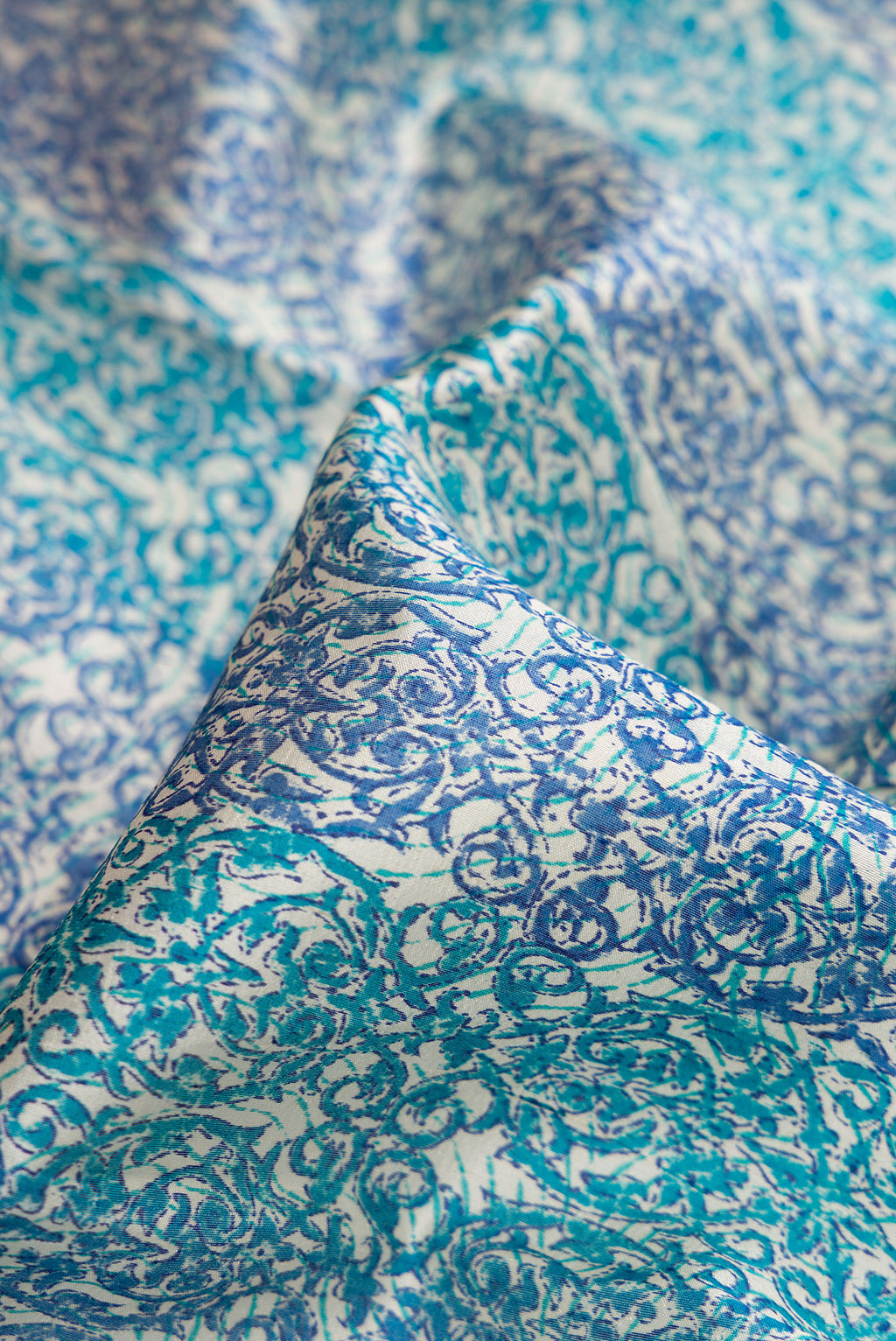 Close up of Sky Blue Dual Tone Tussar Silk Saree with Printed design on the body and Printed Border.  displaying folds