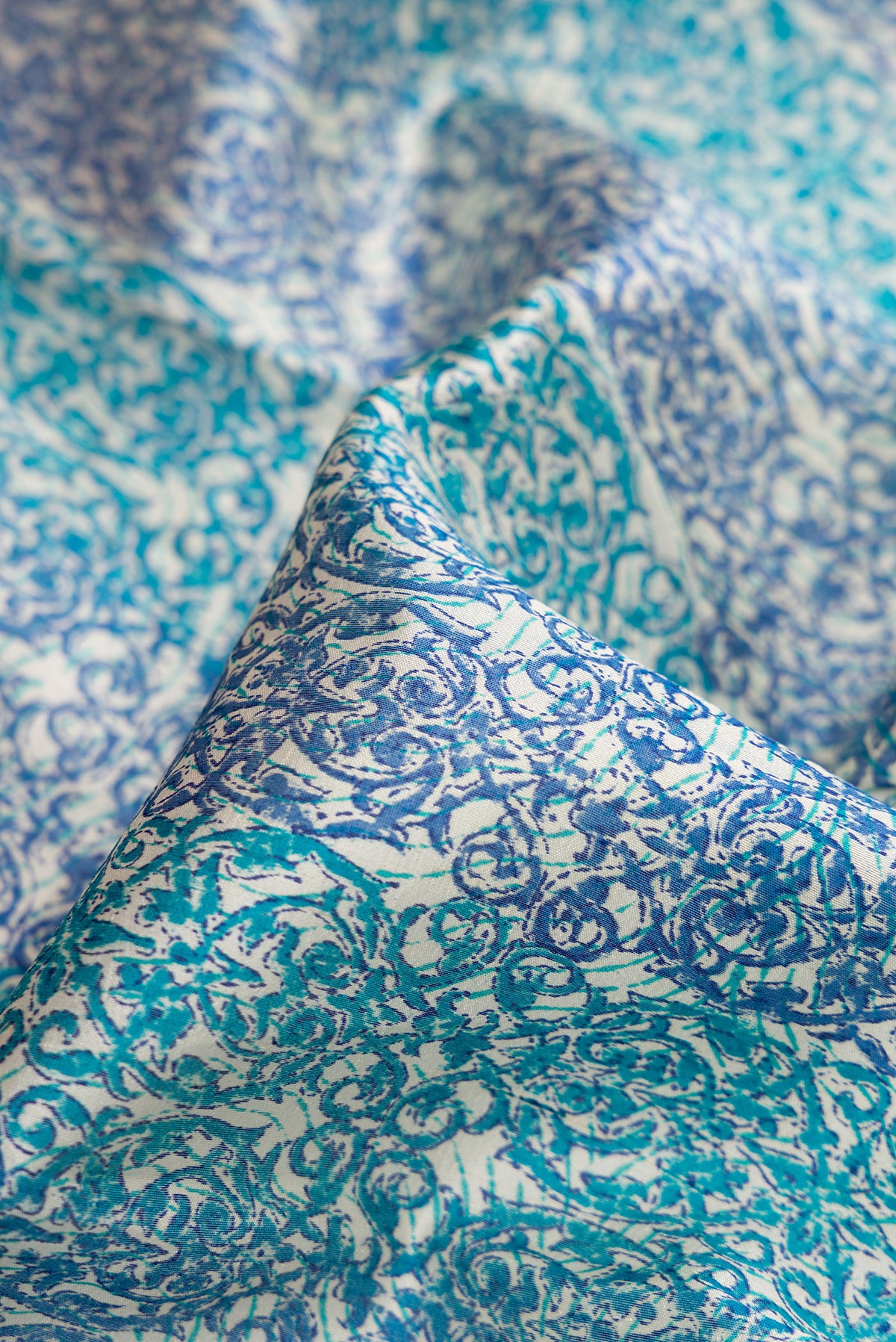 Close up of Sky Blue Dual Tone Tussar Silk Saree with Printed design on the body and Printed Border.  displaying folds