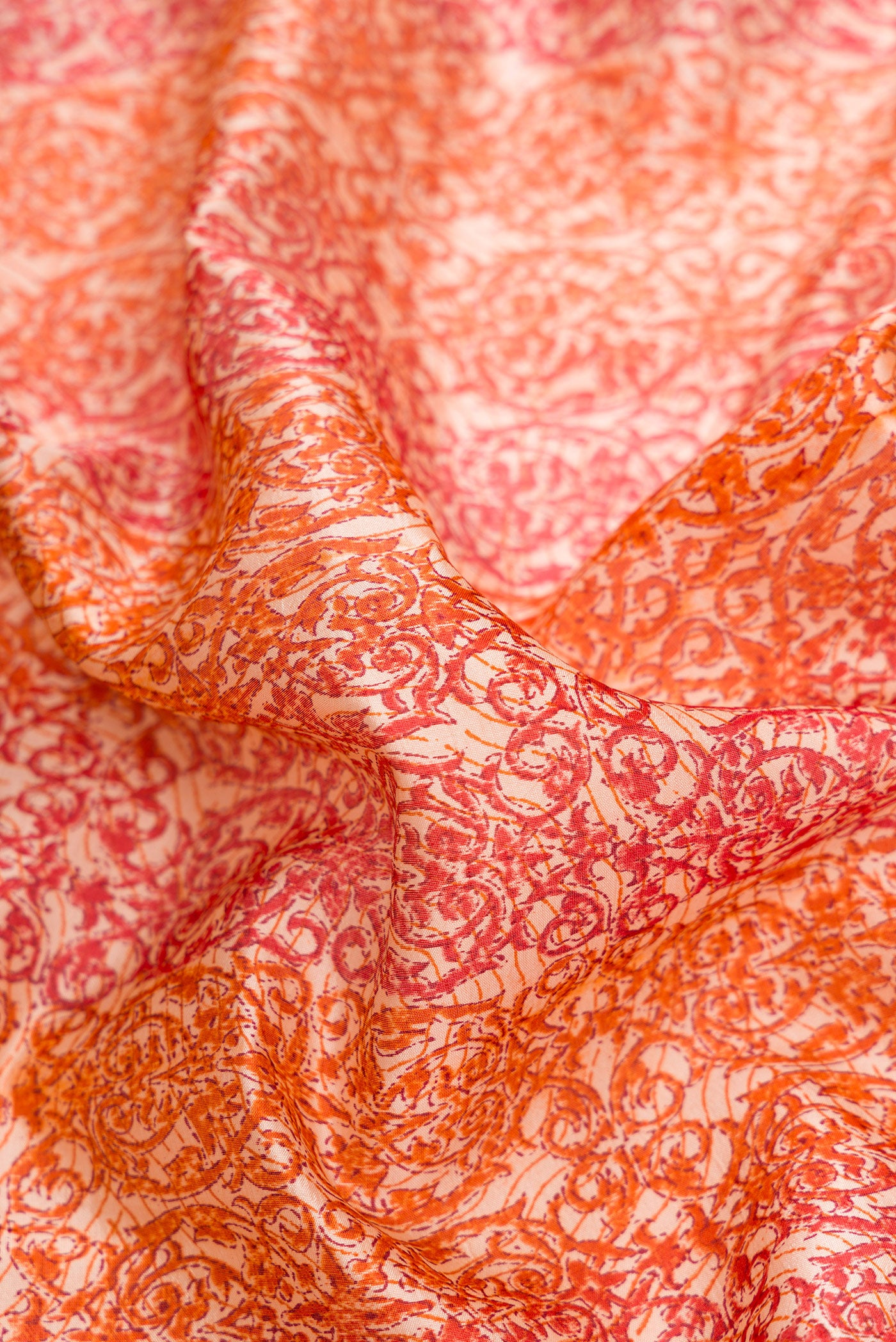 Close up of Orange Dual Tone Tussar Silk Saree with Printed design on the body and Printed Border.  displaying folds