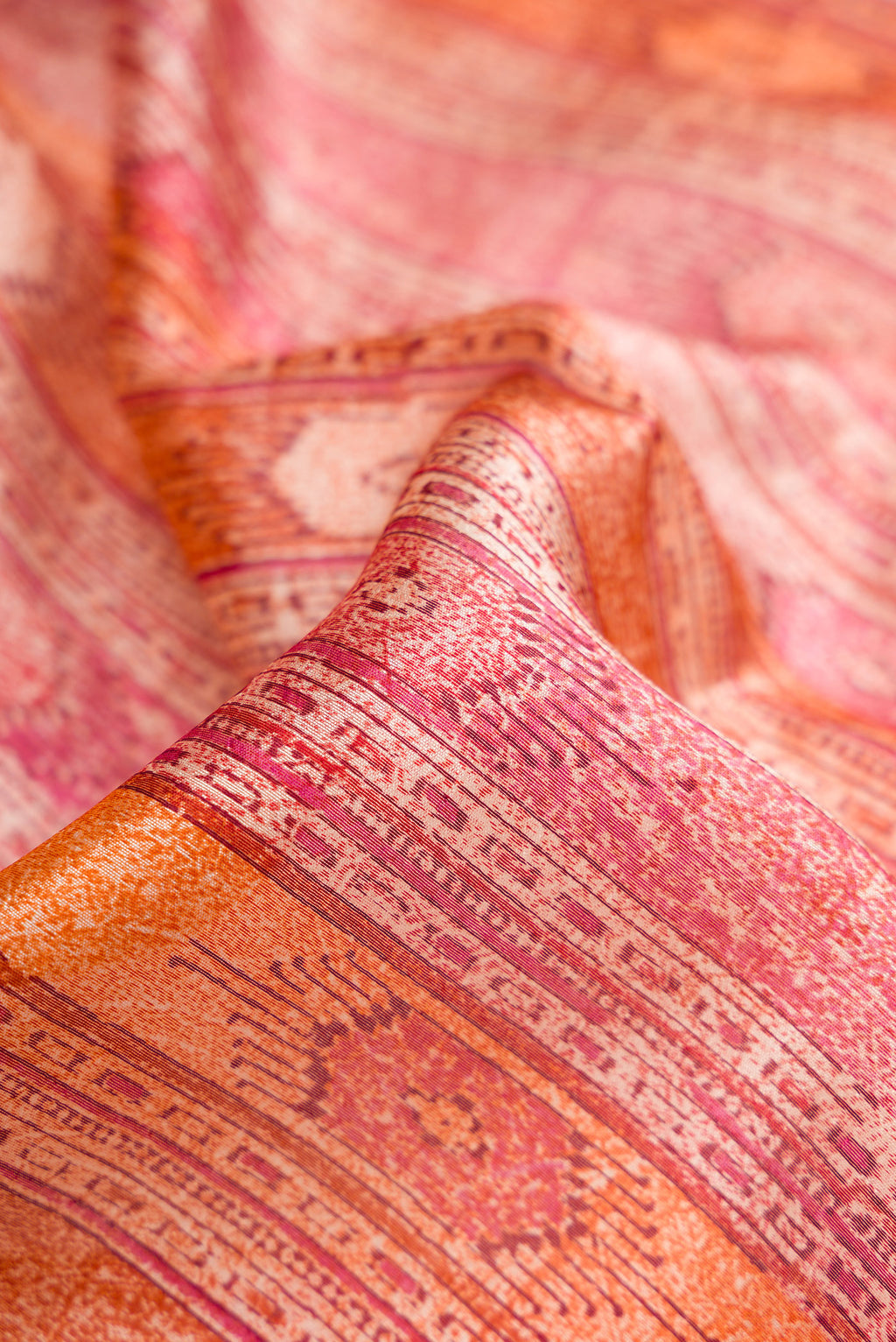 Close up of Coral Dual Tone Tussar Silk Saree with Printed design on the body and Printed Border.  displaying folds