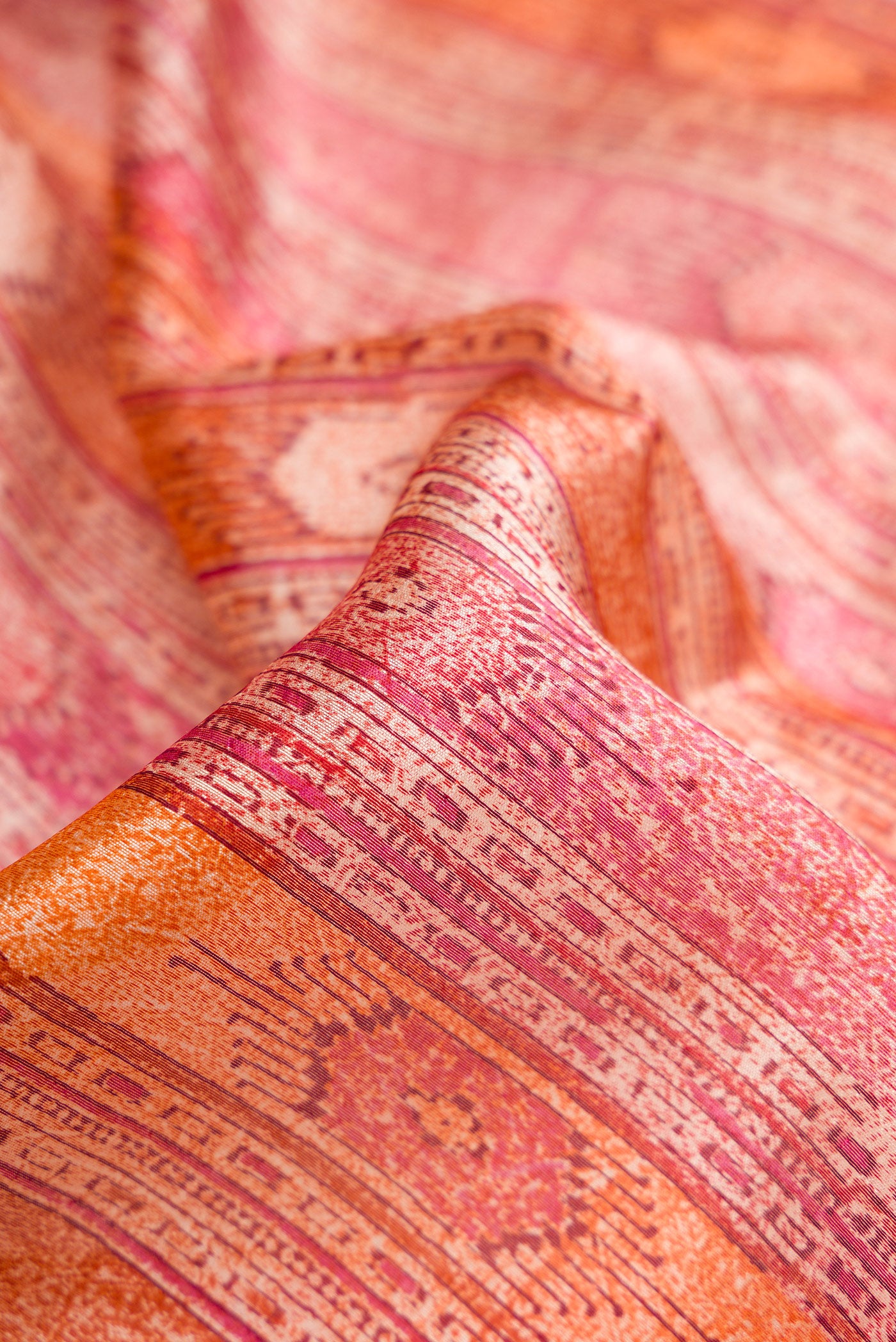 Close up of Coral Dual Tone Tussar Silk Saree with Printed design on the body and Printed Border.  displaying folds
