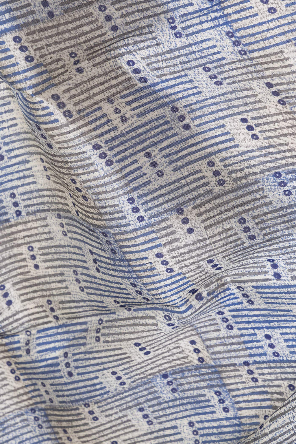 Close up of Beige Tussar Silk Saree with Printed design on the body and Printed Border.  displaying folds