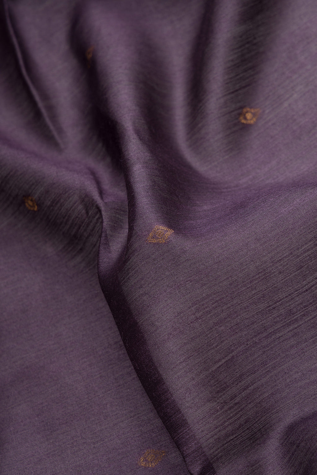 Close up of Violet Dual Tone Tussar Silk Saree with Zari Butta on the body and Ikat Border.  displaying folds