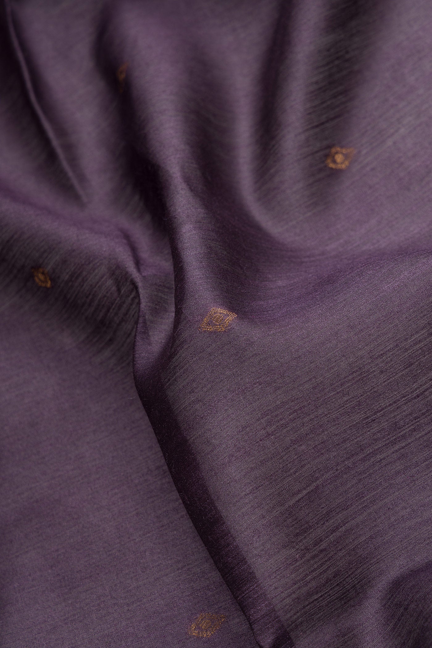 Close up of Violet Dual Tone Tussar Silk Saree with Zari Butta on the body and Ikat Border.  displaying folds